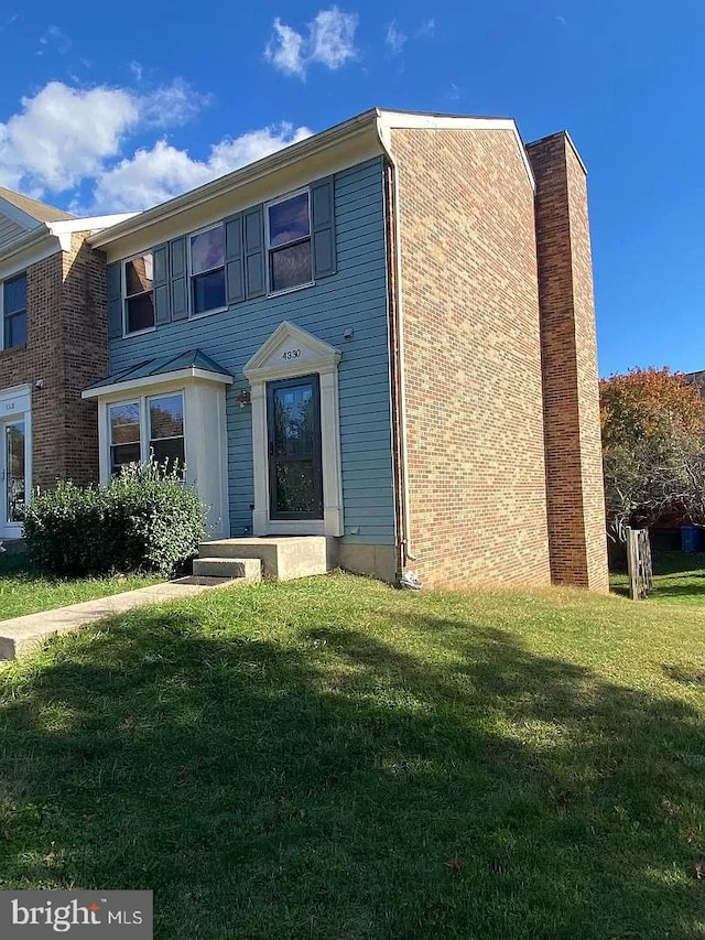 view of front of home featuring a chimney and a front yard