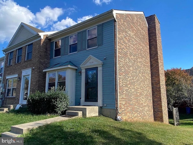 view of front of home featuring a chimney and a front yard