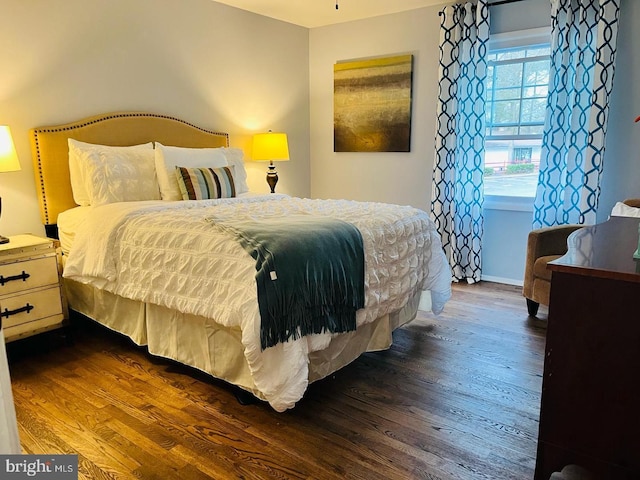 bedroom featuring baseboards and dark wood-style floors