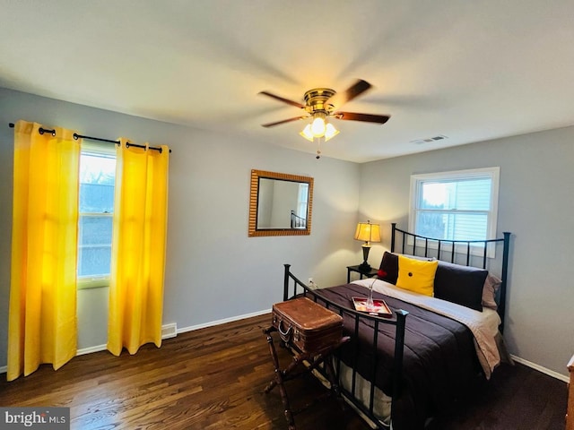 bedroom featuring baseboards, visible vents, a ceiling fan, and wood finished floors