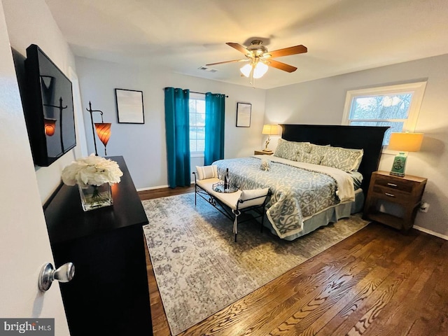 bedroom with ceiling fan, baseboards, visible vents, and wood finished floors