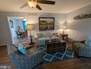 living room with baseboards, visible vents, ceiling fan, and wood finished floors
