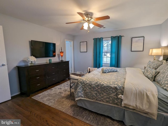 bedroom featuring a ceiling fan, visible vents, and dark wood-type flooring