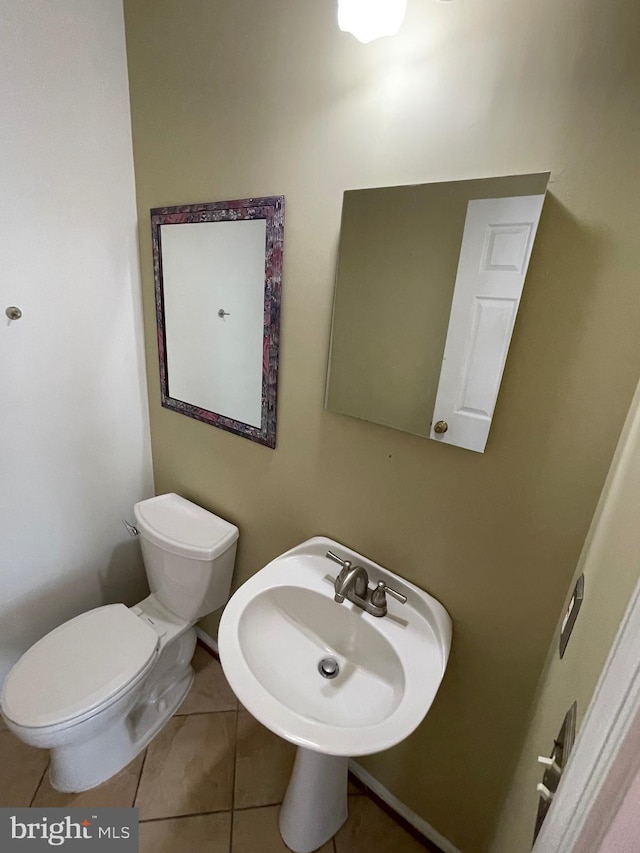 half bath with tile patterned floors and toilet