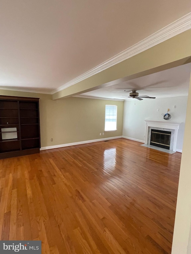 unfurnished living room featuring light wood-type flooring, a ceiling fan, crown molding, and a premium fireplace