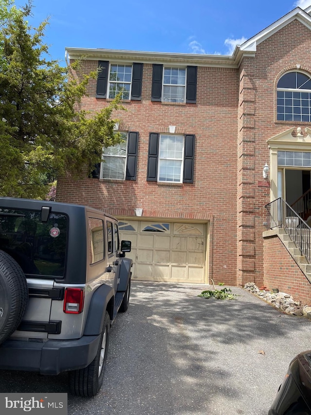 view of front of house featuring brick siding, an attached garage, and driveway