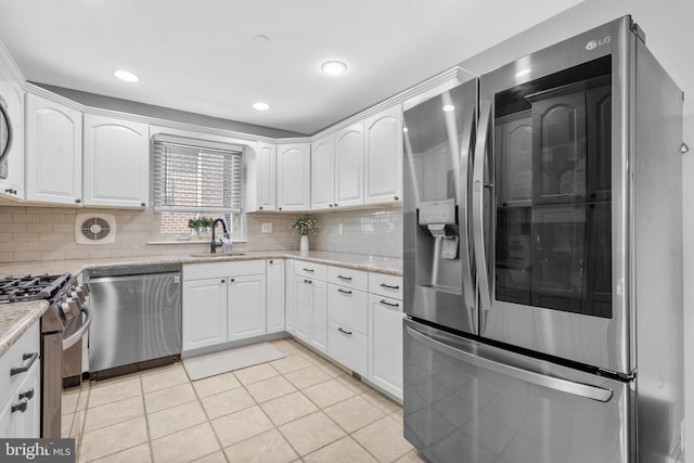 kitchen with a sink, decorative backsplash, white cabinetry, and stainless steel appliances