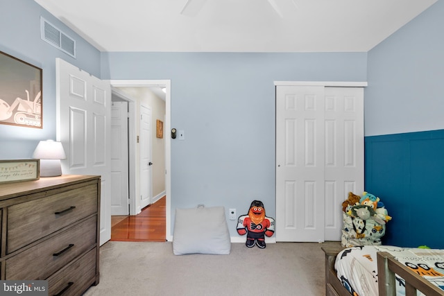 bedroom featuring carpet flooring, ceiling fan, visible vents, and a closet