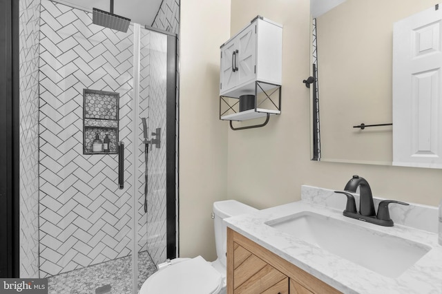 bathroom featuring vanity, a shower stall, and toilet