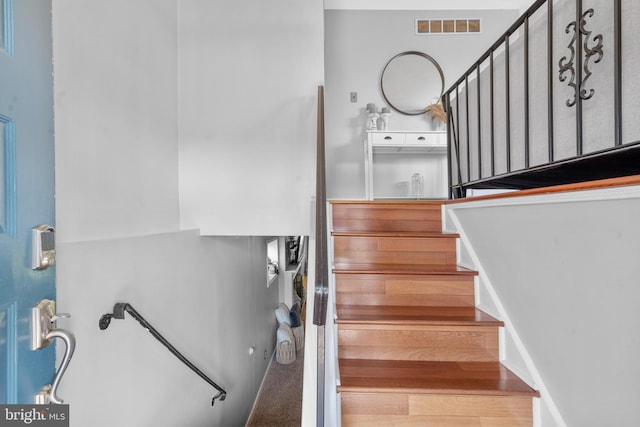 staircase featuring visible vents and wood finished floors
