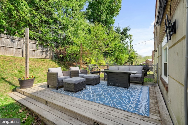 deck featuring outdoor lounge area, fence, and a yard