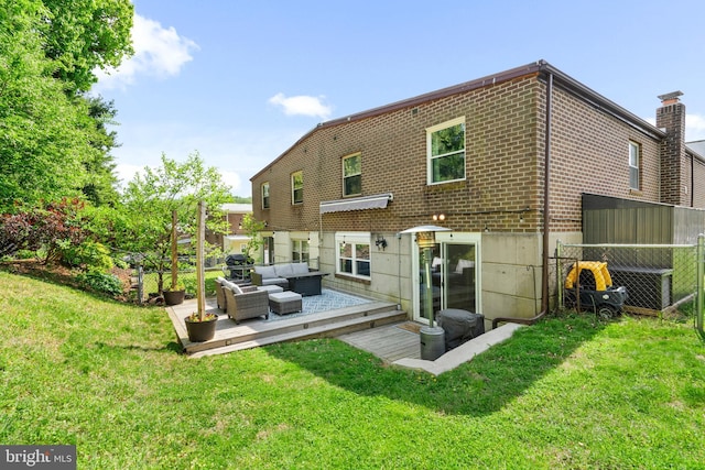 rear view of house with brick siding, fence, a yard, and an outdoor hangout area