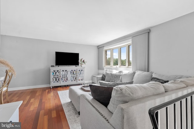 living area with baseboards and wood finished floors