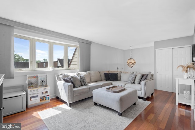 living area featuring wood-type flooring and a notable chandelier