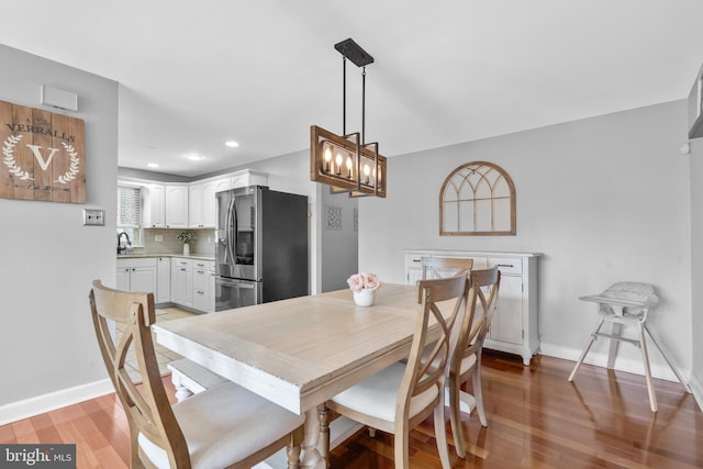 dining room with recessed lighting, baseboards, an inviting chandelier, and light wood finished floors