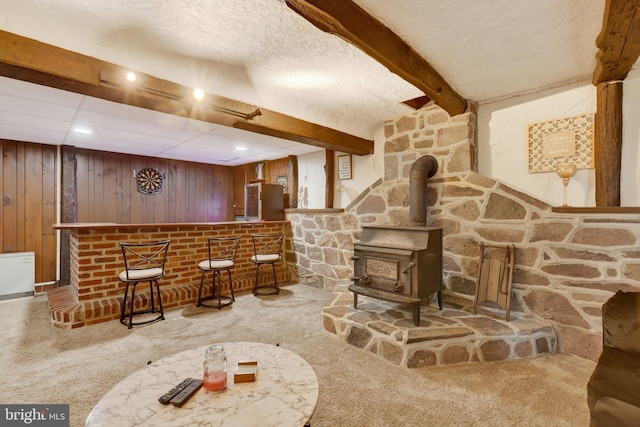 38 Bonniefield Cir, Gettysburg, PA 17325 - indoor dry bar featuring a wood stove, carpet flooring, wooden walls, and beam ceiling