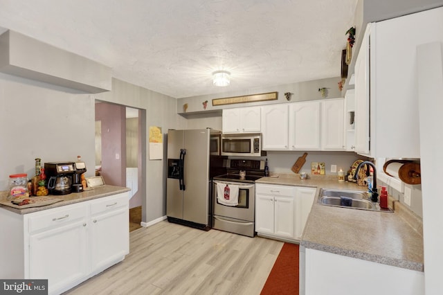 38 Bonniefield Cir, Gettysburg, PA 17325 - kitchen featuring stainless steel appliances, a sink, light wood finished floors, white cabinetry, and light countertops