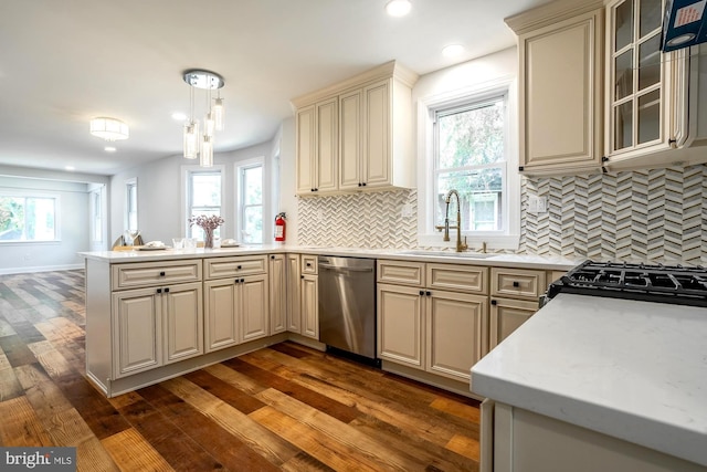 kitchen with stainless steel dishwasher, dark wood-style flooring, a peninsula, light countertops, and cream cabinetry