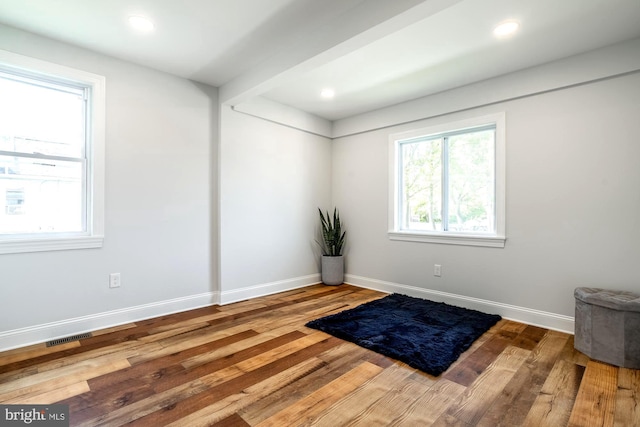unfurnished room featuring baseboards, recessed lighting, wood finished floors, and visible vents