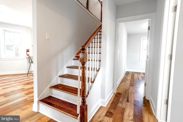 staircase with baseboards and wood finished floors