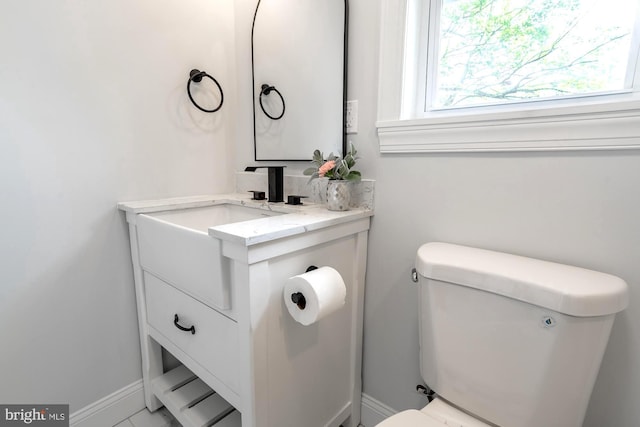 bathroom with vanity, baseboards, and toilet