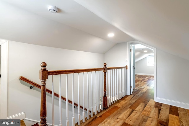 additional living space featuring baseboards, vaulted ceiling, and wood finished floors