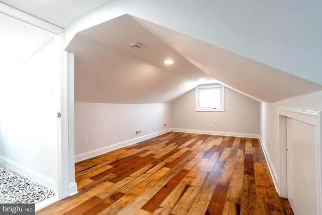 bonus room with baseboards, vaulted ceiling, hardwood / wood-style floors, and visible vents