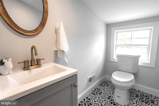 bathroom featuring visible vents, baseboards, tile patterned floors, vanity, and toilet