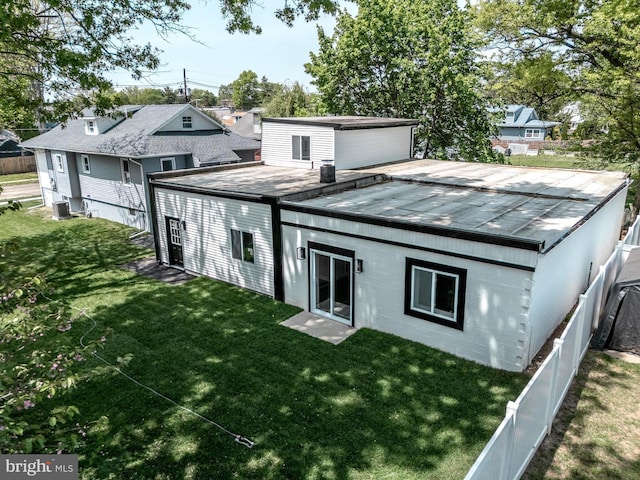 rear view of property with a lawn, fence, and cooling unit