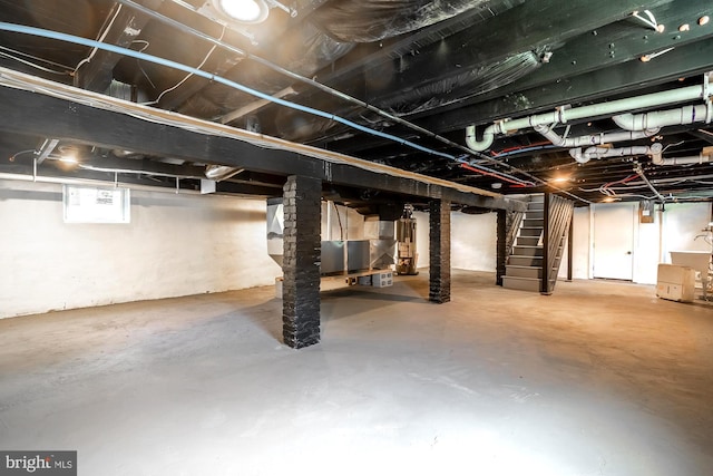 basement featuring water heater and stairs