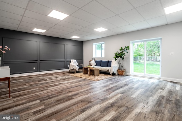 sitting room with baseboards, wood finished floors, and a paneled ceiling