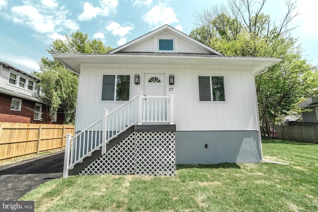bungalow-style house with fence and a front yard