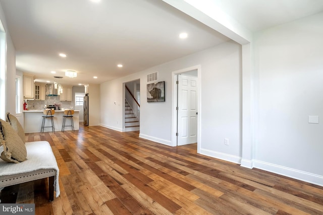 living area featuring stairs, recessed lighting, baseboards, wood finished floors, and visible vents