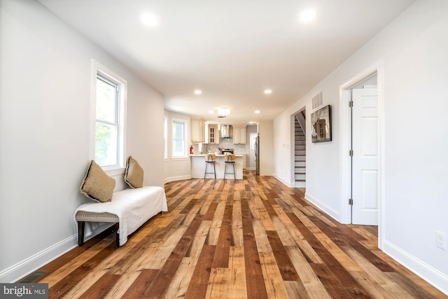 living area with recessed lighting, visible vents, and wood finished floors
