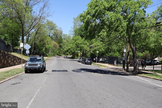 view of road with curbs, traffic signs, and sidewalks