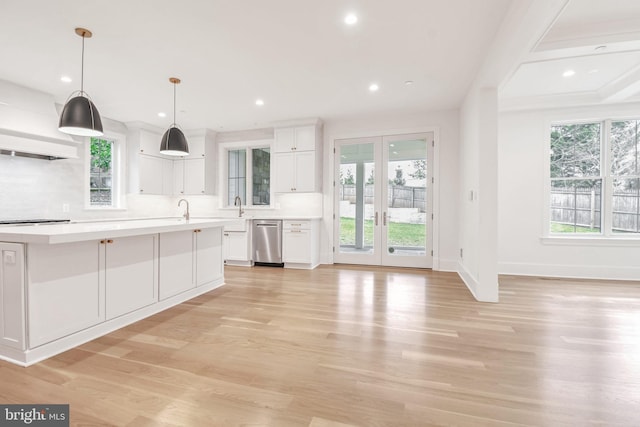 kitchen featuring light countertops, white cabinets, light wood finished floors, and dishwasher