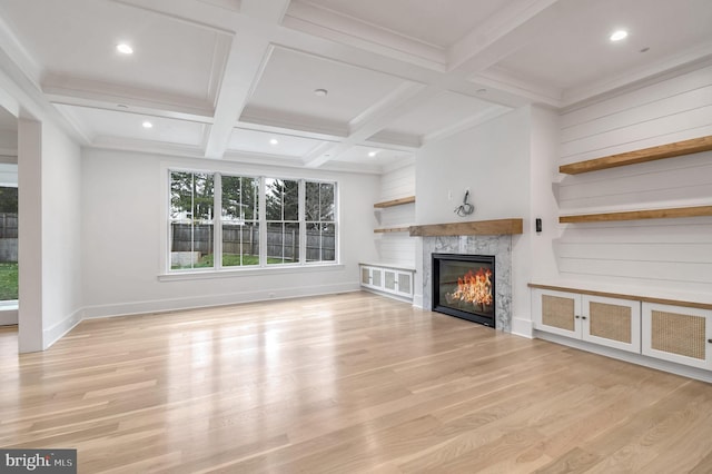 unfurnished living room with a glass covered fireplace, wood finished floors, beam ceiling, recessed lighting, and coffered ceiling