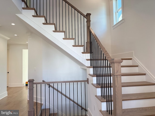 stairway with crown molding, baseboards, recessed lighting, and wood finished floors