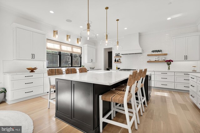 kitchen featuring open shelves, premium range hood, a center island, white cabinetry, and tasteful backsplash