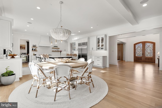 dining room with recessed lighting, an inviting chandelier, beam ceiling, and light wood finished floors
