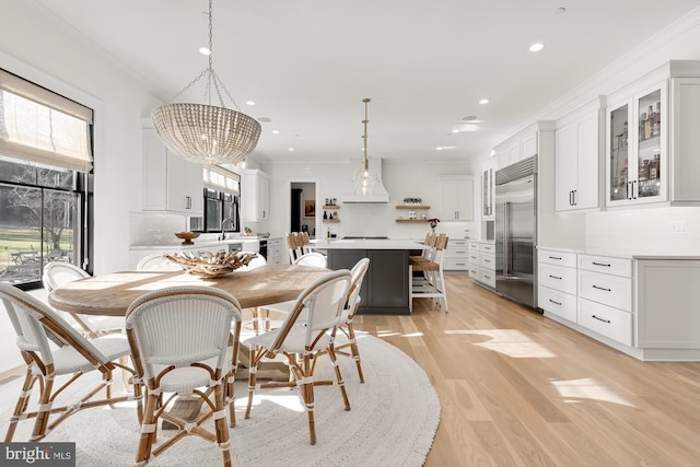 dining room featuring light wood-type flooring, ornamental molding, a chandelier, and recessed lighting
