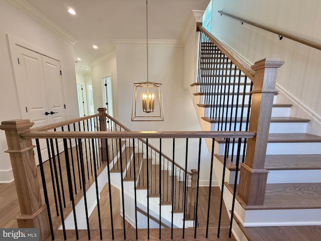stairs with recessed lighting, a chandelier, ornamental molding, and wood finished floors