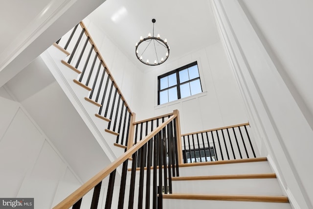 stairs with a notable chandelier