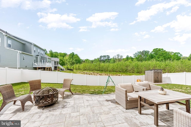 24083 Woodmore Dr, Hollywood, MD 20636 - view of patio featuring an outdoor structure, a fenced backyard, an outdoor fire pit, and a storage shed