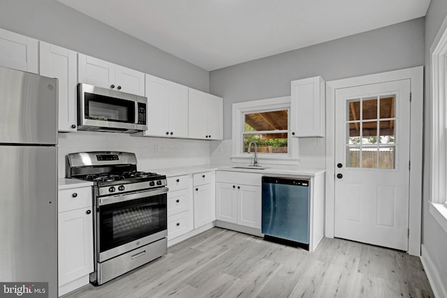 536 Lafayette St, Lancaster, PA 17603 - kitchen with appliances with stainless steel finishes, a sink, light countertops, light wood-style floors, and tasteful backsplash