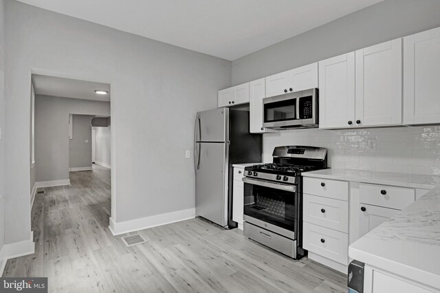 536 Lafayette St, Lancaster, PA 17603 - kitchen with stainless steel appliances, light wood finished floors, backsplash, baseboards, and light countertops