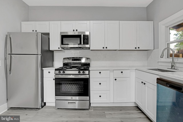 536 Lafayette St, Lancaster, PA 17603 - kitchen featuring appliances with stainless steel finishes, a sink, decorative backsplash, and white cabinetry