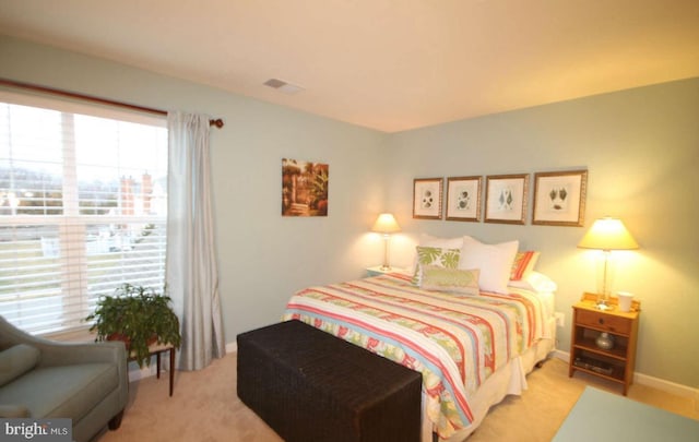 bedroom with visible vents and light carpet