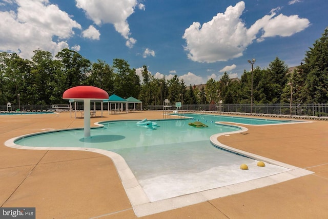 community pool featuring a patio and fence