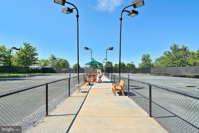 view of tennis court featuring fence